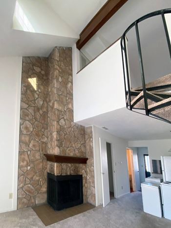 A stone wall with a fireplace in front of it.